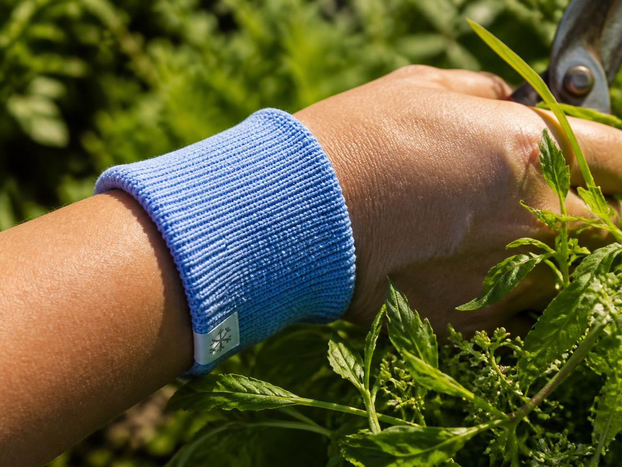 Person wearing a blue BreezeCuff cooling cuff while gardening